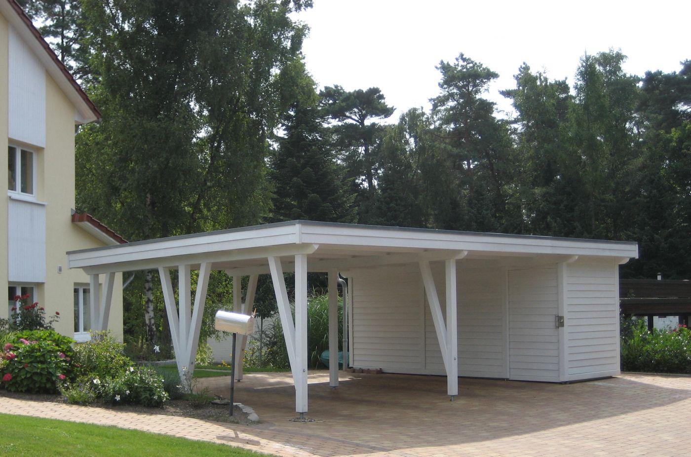 Doppelcarport mit versteckter Schiebetür im Abstellraum